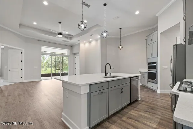 a kitchen with stainless steel appliances granite countertop a sink a refrigerator and a stove