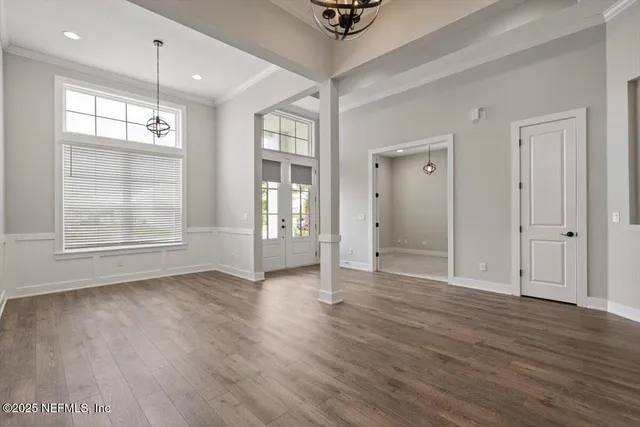 an empty room with wooden floor and mirror