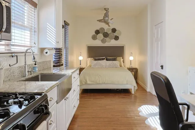 a bedroom with a bed and a dresser next to a window