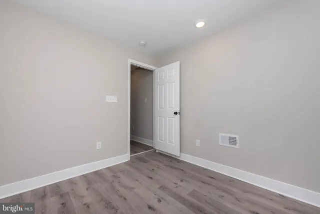 an empty room with wooden floor and entrance
