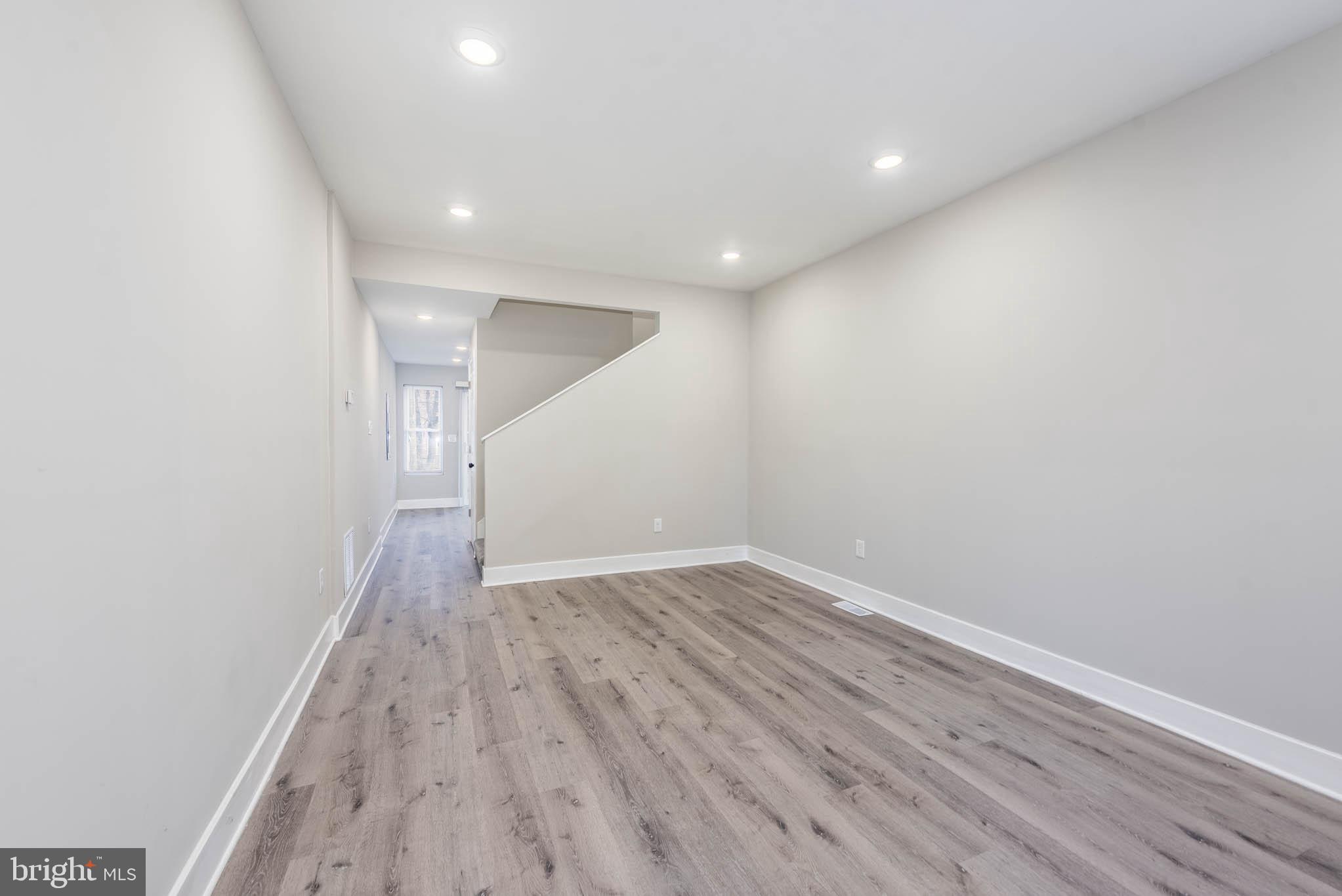 1011 North Mount Street Baltimore, MD 21217 - Photo 2 of 23 a view of an empty room with wooden floor