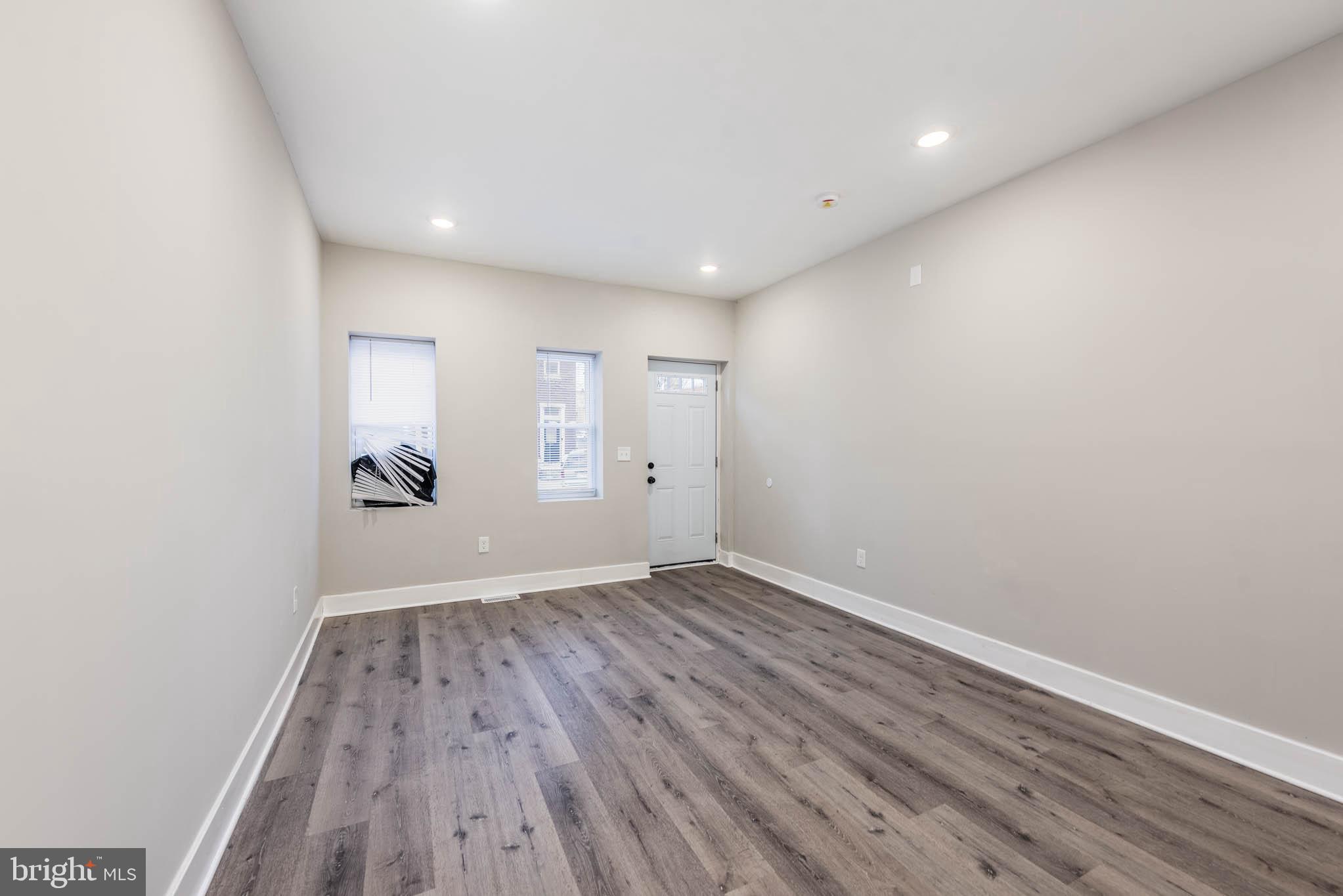 1011 North Mount Street Baltimore, MD 21217 - Photo 4 of 23 a view of an empty room with wooden floor and a window