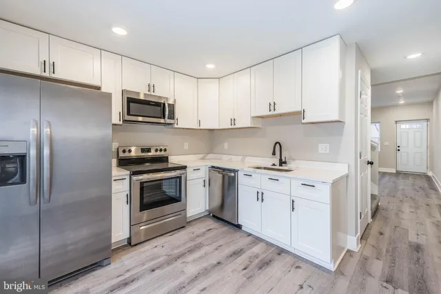 a kitchen with stainless steel appliances granite countertop a stove a sink and a refrigerator