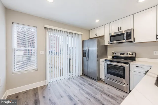 a kitchen with stainless steel appliances granite countertop a stove a refrigerator and a microwave