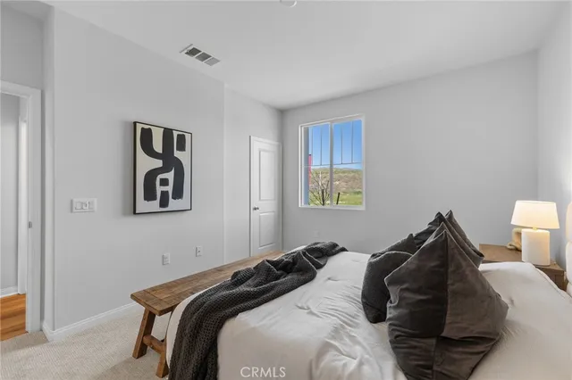 a bedroom with two beds and potted plant