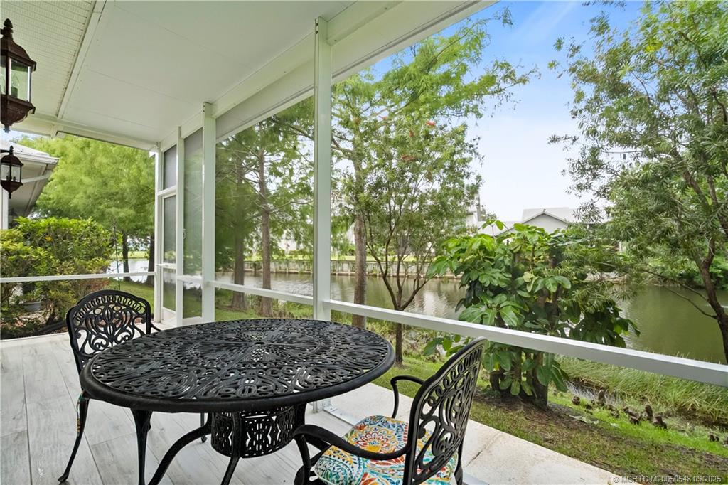 2194 Northwest Tilia Trail Stuart, FL 34994 - Photo 6 of 39 a view of a balcony with table and chairs and wooden floor