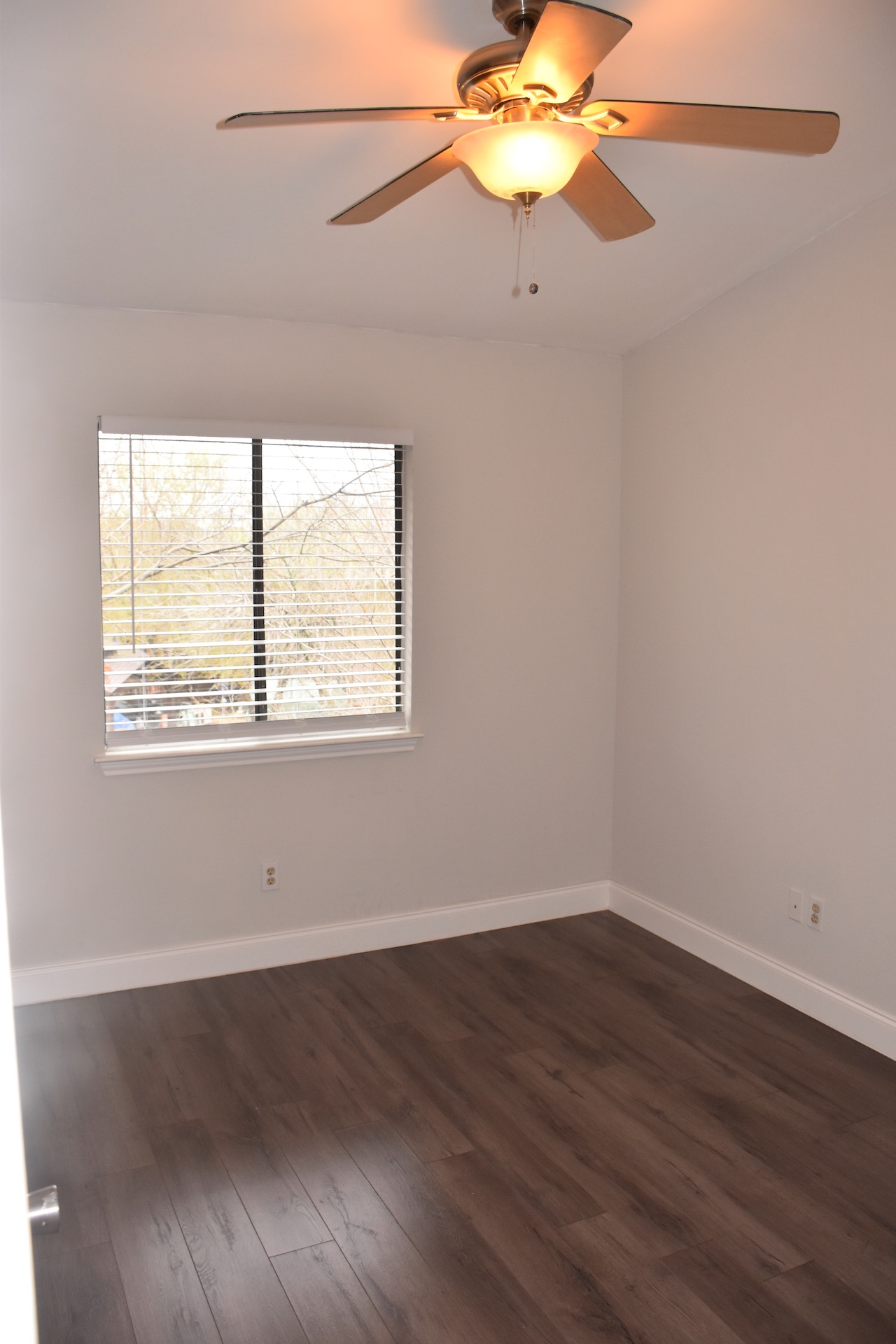 1810 Rawhide Loop Round Rock, TX 78681 - Photo 25 of 29 Interior room featuring wood-finish flooring, white baseboards, a window with horizontal blinds, and an overhead ceiling fan with integrated lighting