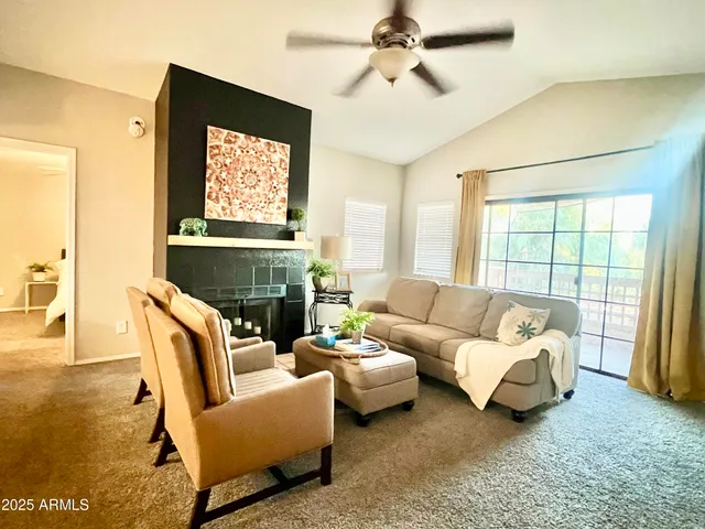 a living room with furniture a flat screen tv and a large window