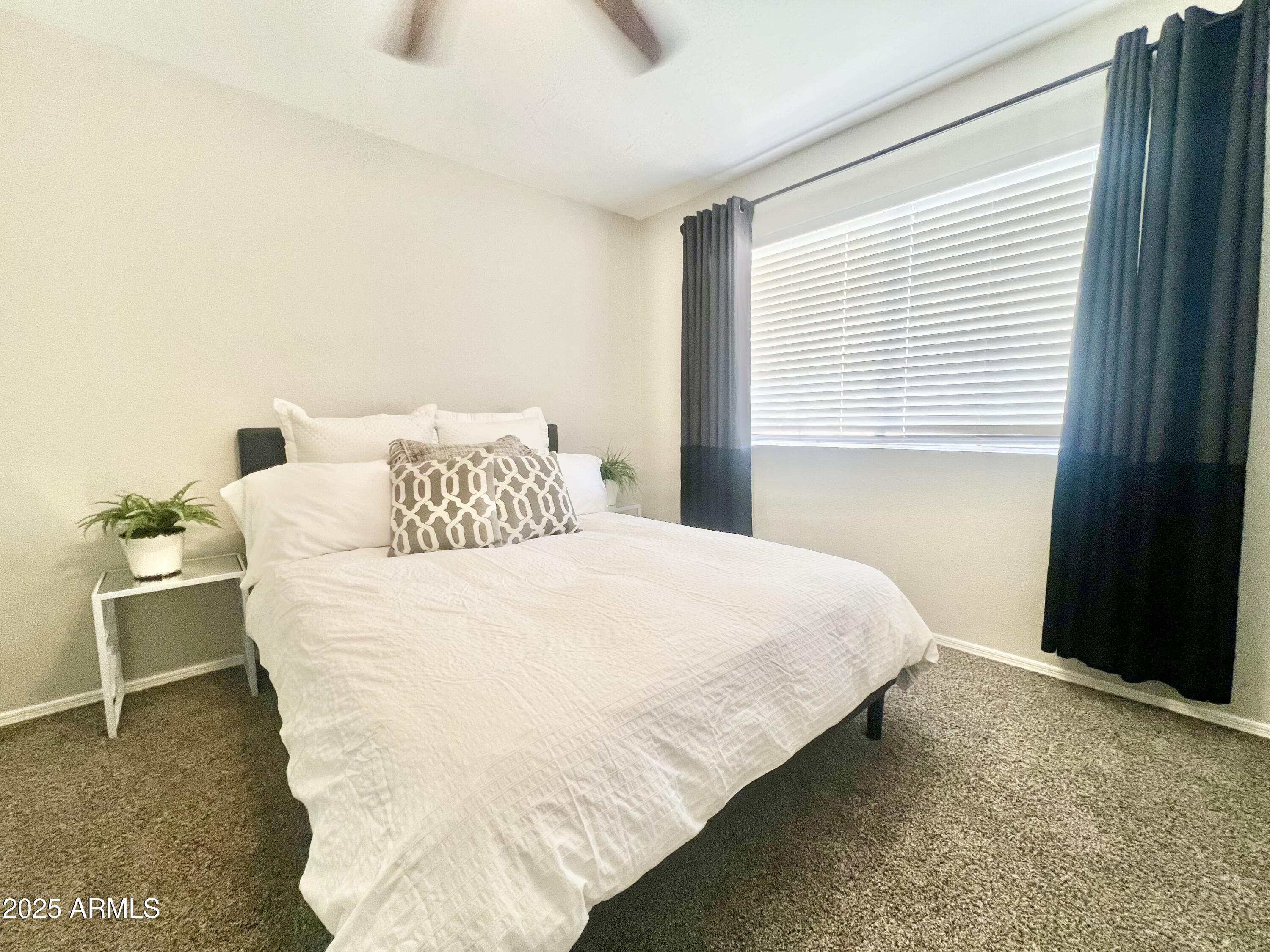 2855 South Ext Road, Unit 220 Mesa, AZ 85210 - Photo 13 of 40 a large bed sitting in a bedroom next to a window