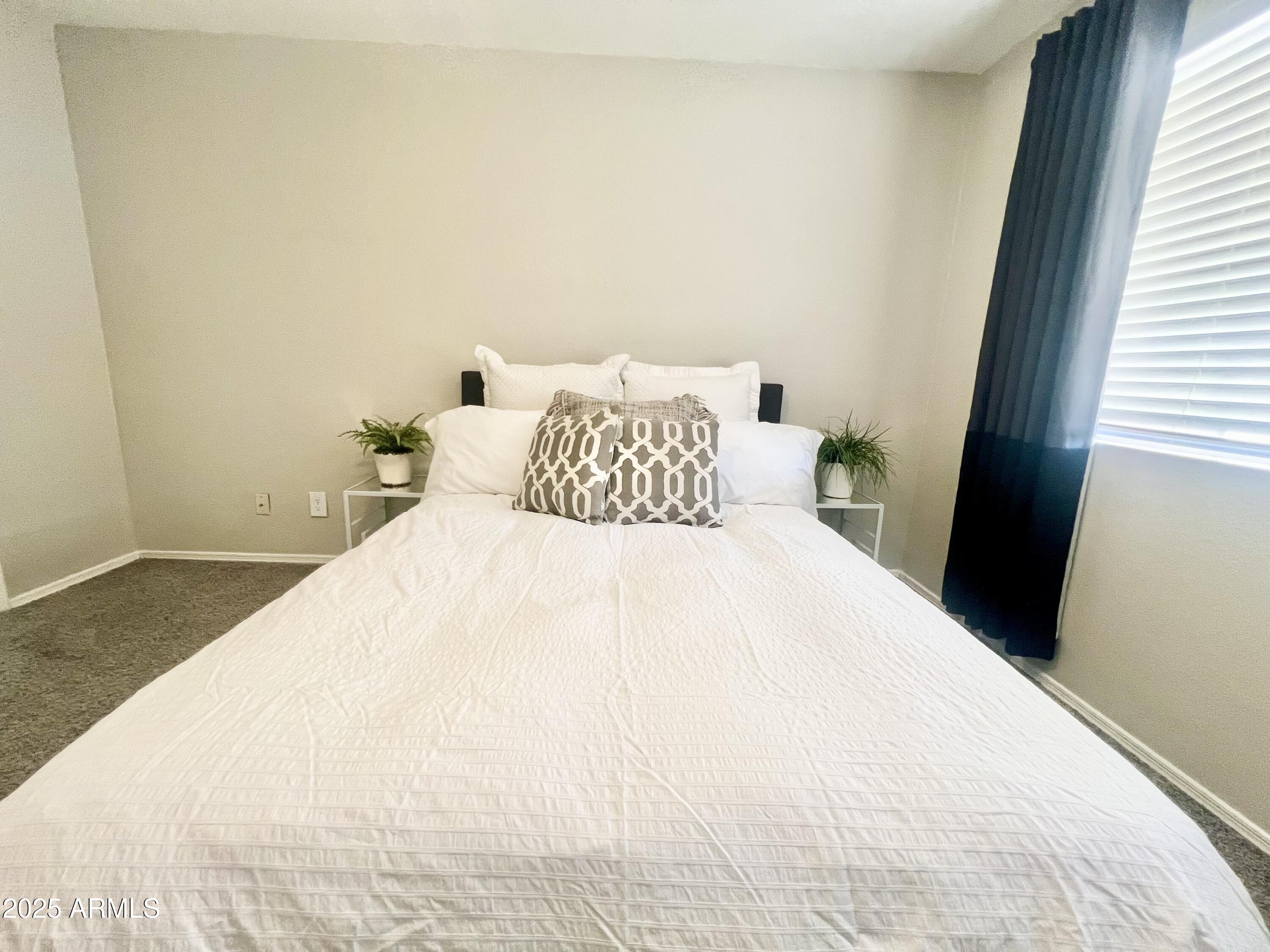 2855 South Ext Road, Unit 220 Mesa, AZ 85210 - Photo 15 of 40 a large white bed in a small room