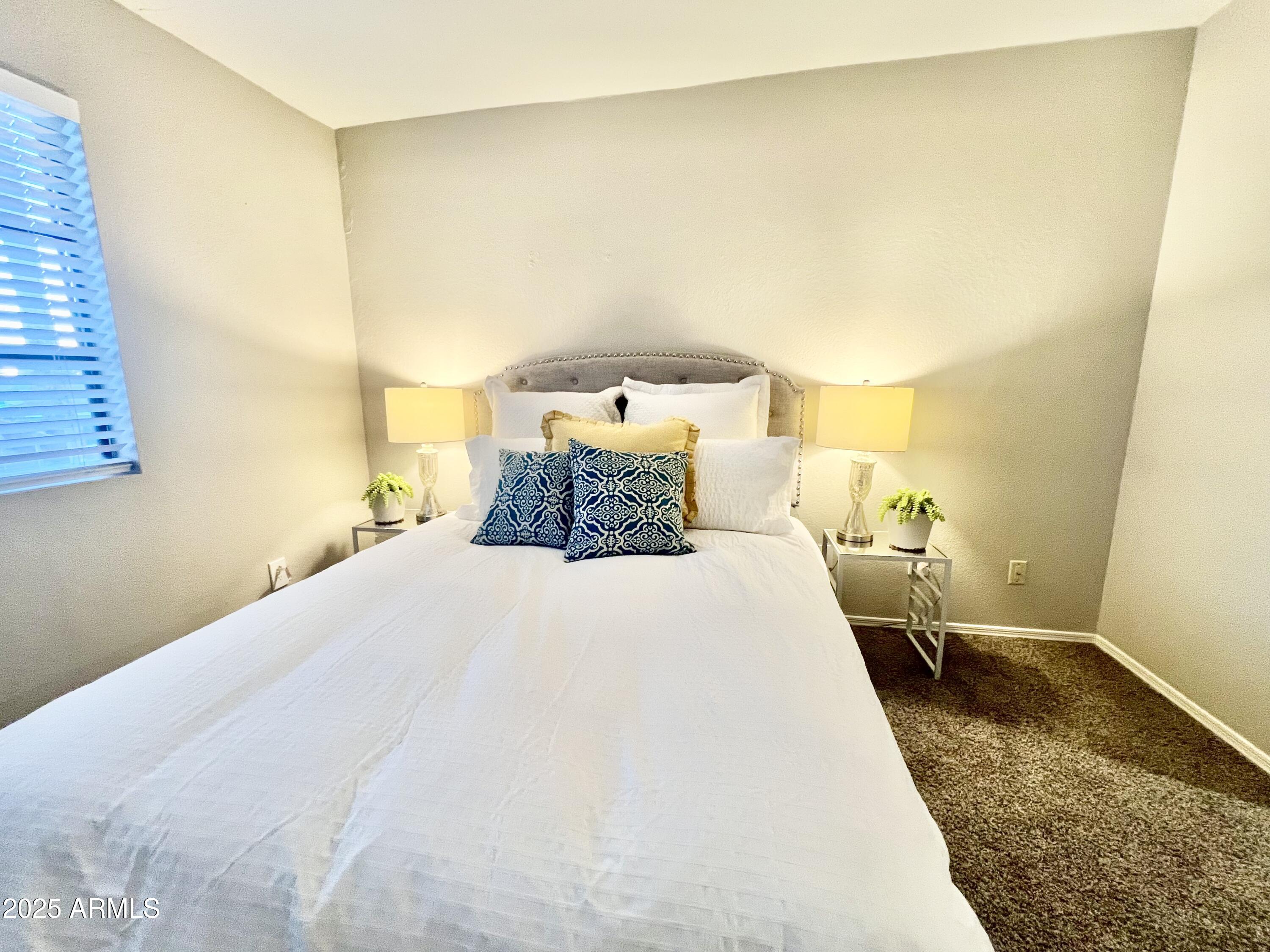 2855 South Ext Road, Unit 220 Mesa, AZ 85210 - Photo 22 of 40 a bedroom with a bed and lamps