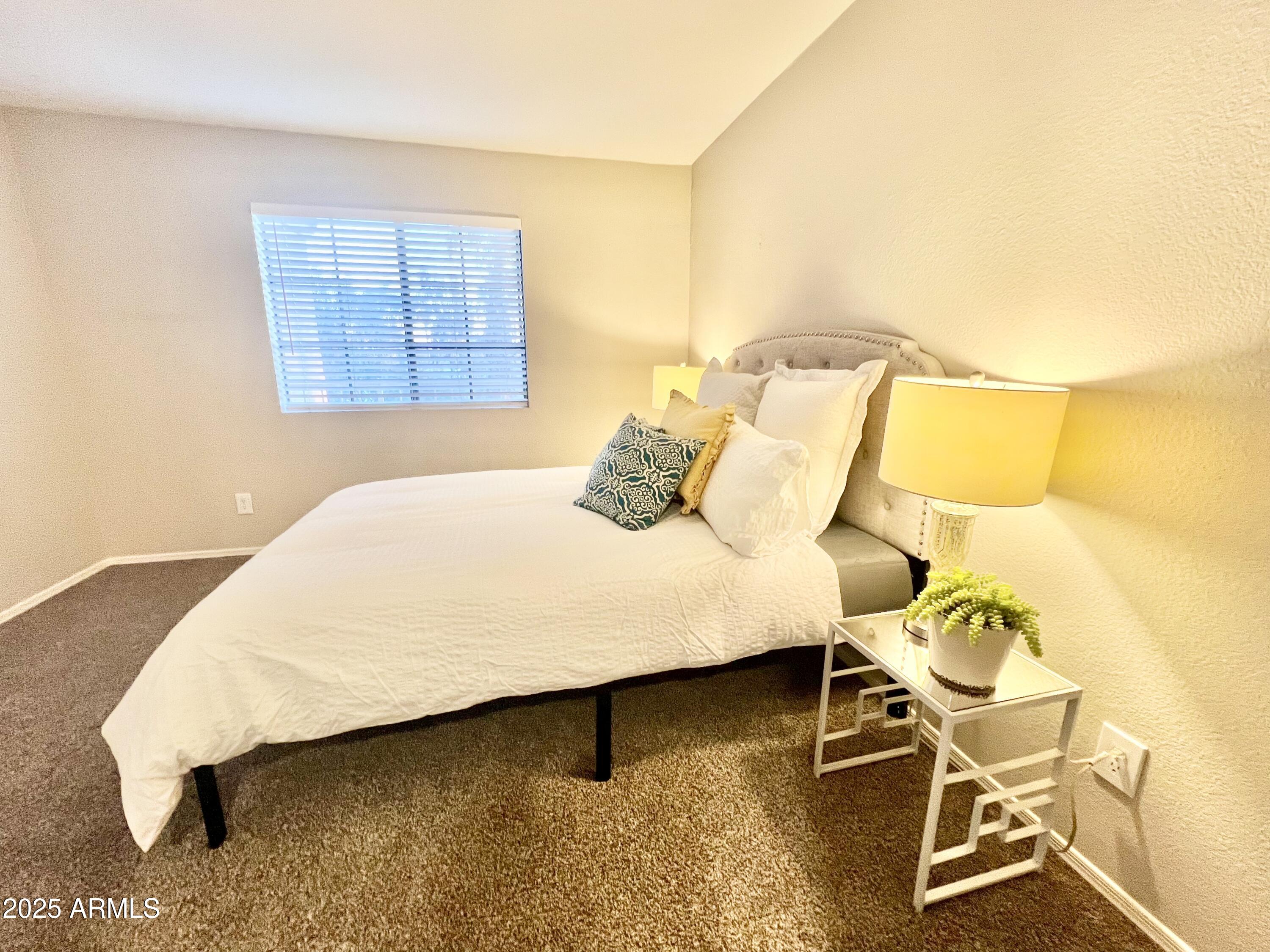 2855 South Ext Road, Unit 220 Mesa, AZ 85210 - Photo 26 of 40 a bedroom with a bed and a table in it