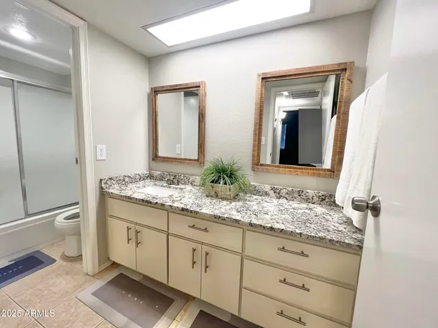 a bathroom with a granite countertop sink and a mirror