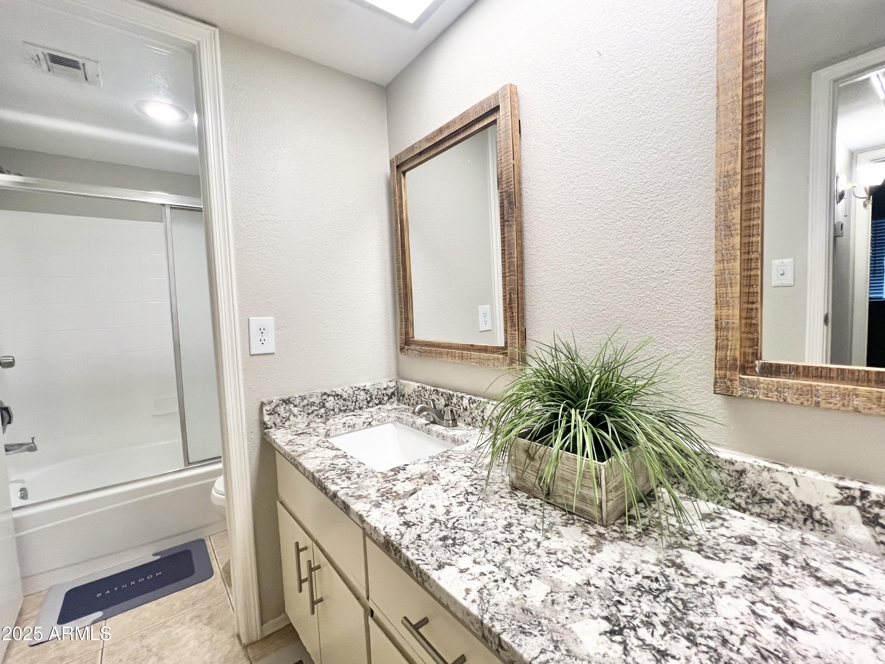 2855 South Ext Road, Unit 220 Mesa, AZ 85210 - Photo 28 of 40 a bathroom with a granite countertop sink and a mirror
