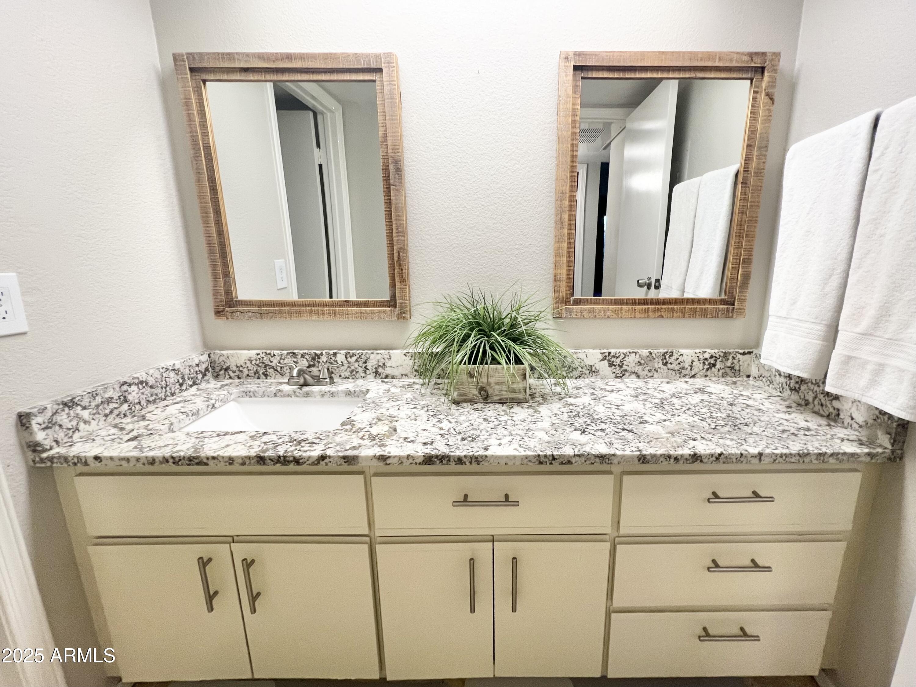 2855 South Ext Road, Unit 220 Mesa, AZ 85210 - Photo 30 of 40 a bathroom with a granite countertop sink and a mirror