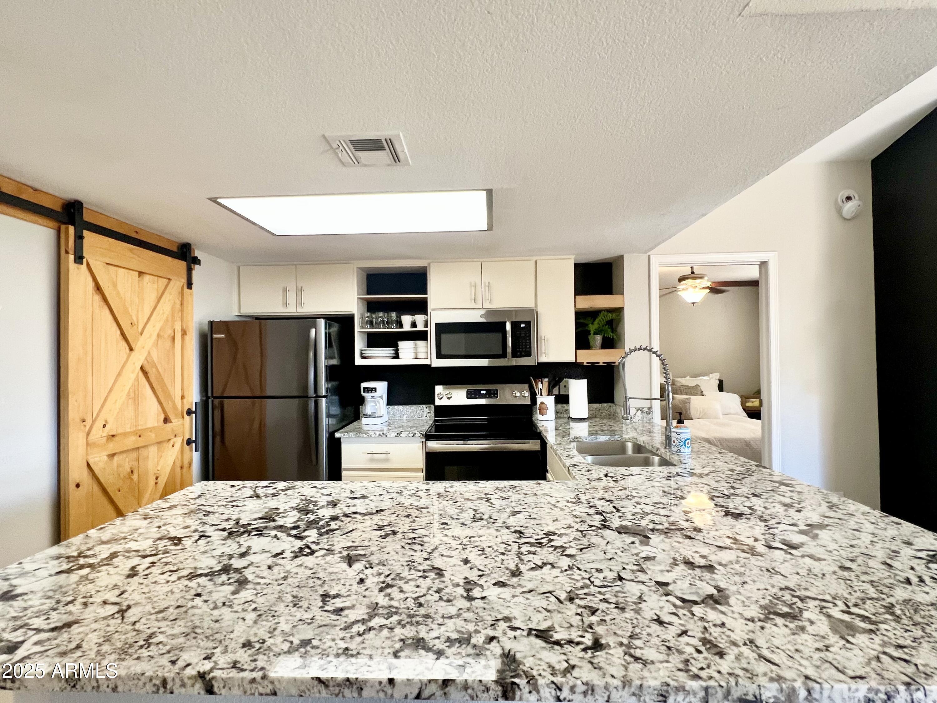 2855 South Ext Road, Unit 220 Mesa, AZ 85210 - Photo 6 of 40 a kitchen with a refrigerator and a stove top oven