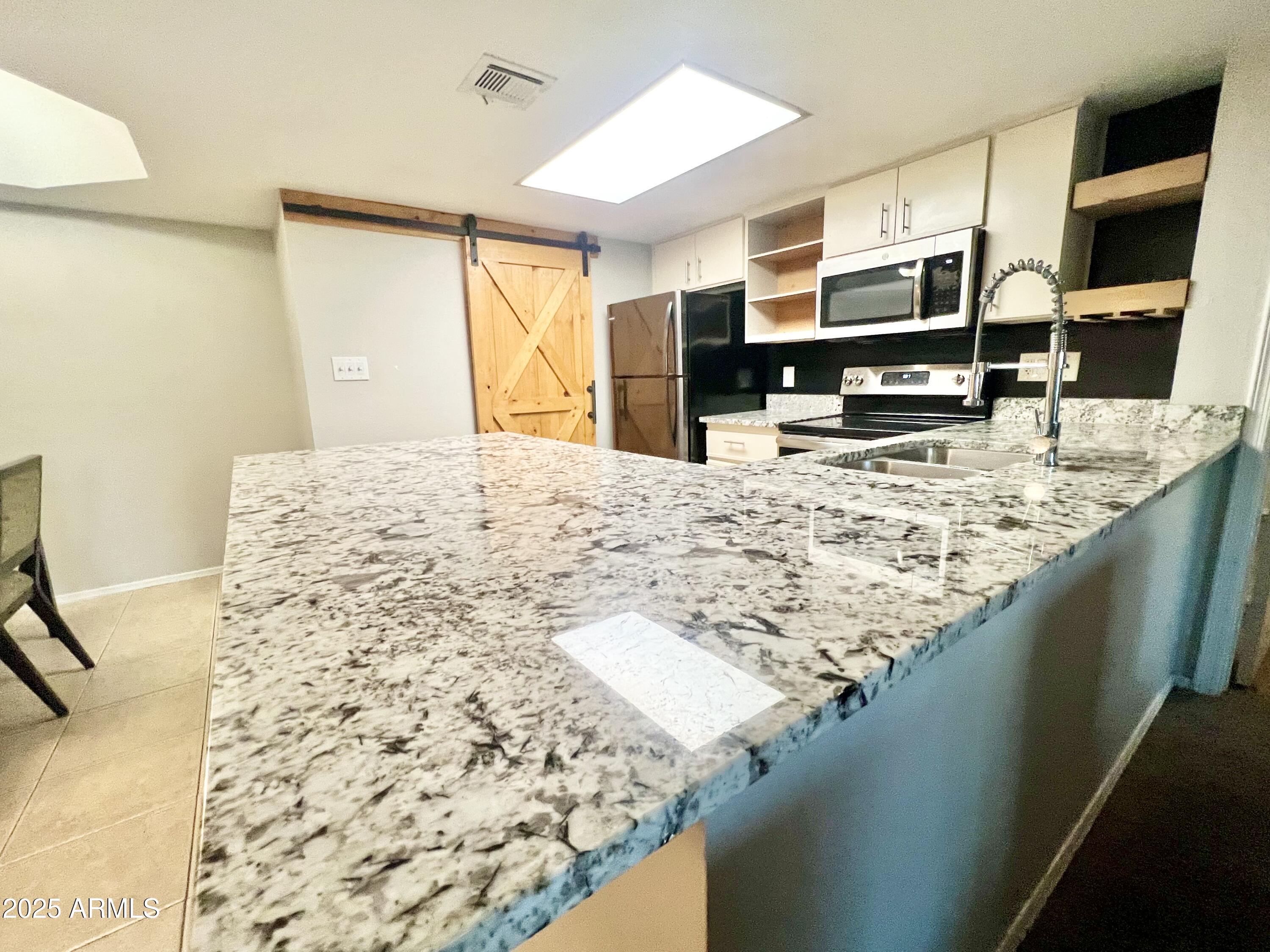 2855 South Ext Road, Unit 220 Mesa, AZ 85210 - Photo 8 of 40 a living room with kitchen island granite countertop furniture and a flat screen tv