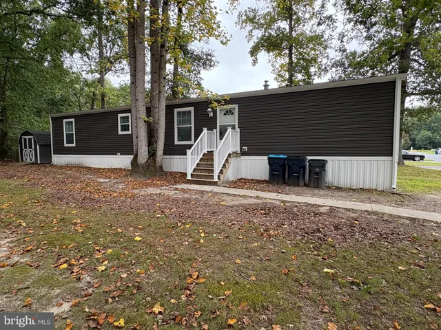 a view of a house with backyard and a tree