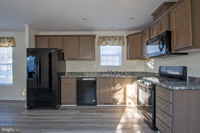 a kitchen with stainless steel appliances granite countertop a refrigerator and a stove top oven