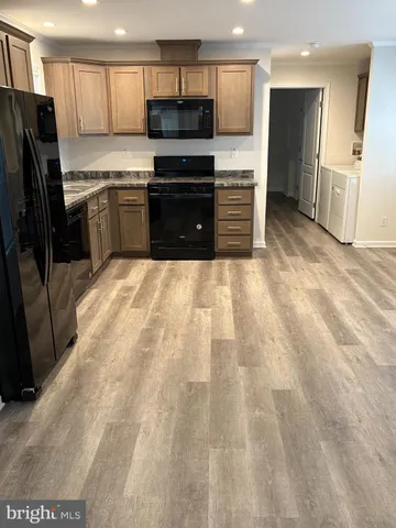 a large kitchen with a stove a refrigerator and a sink