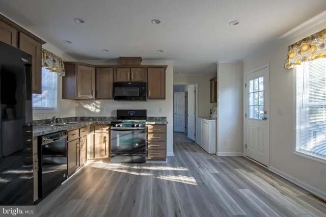 a kitchen with granite countertop a stove a sink and a refrigerator