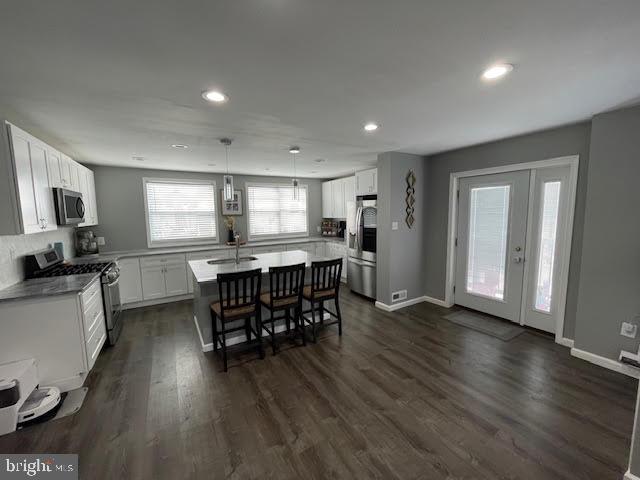 10848 Perrin Road Philadelphia, PA 19154 - Photo 5 of 38 a kitchen with stainless steel appliances granite countertop a stove top oven a sink dishwasher a dining table and chairs with wooden floor