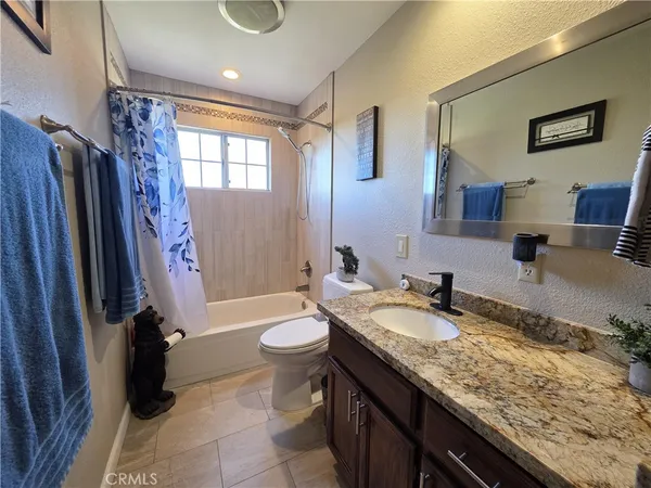 a spacious bathroom with a granite countertop tub sink and mirror