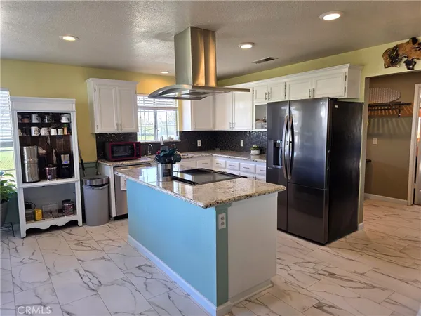 a kitchen with stainless steel appliances granite countertop a refrigerator a stove and a sink