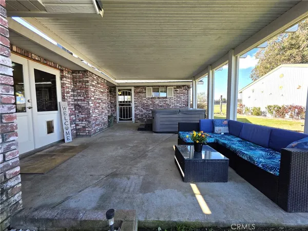 a view of a house next to a big yard with plants and large trees