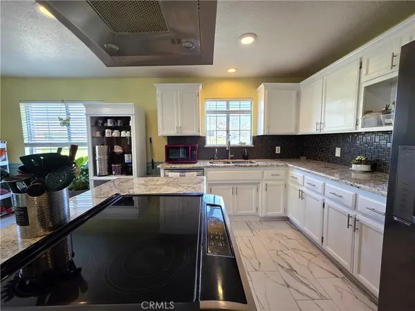 a large kitchen with stainless steel appliances kitchen island granite countertop a sink and cabinets