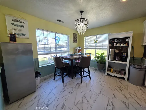 a large kitchen with stainless steel appliances kitchen island a large counter top a stove a refrigerator cabinets and living room view