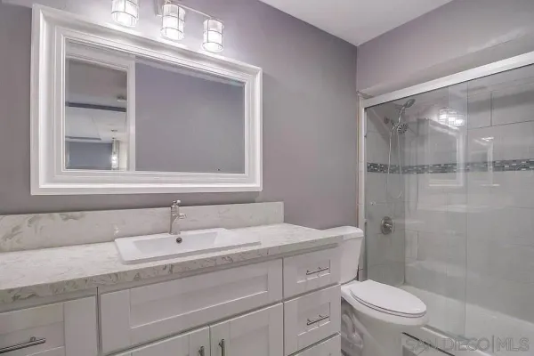 a bathroom with a sink a toilet and shower