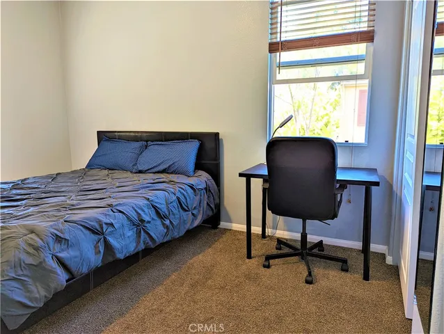 a large bed sitting in a bedroom next to a window