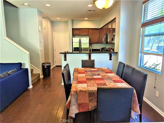 a dining room with stainless steel appliances furniture a window and kitchen view