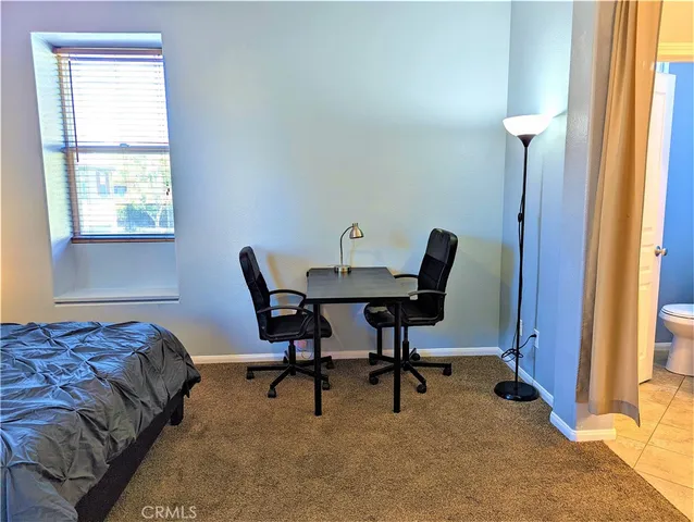 a bedroom with a bed chair and window