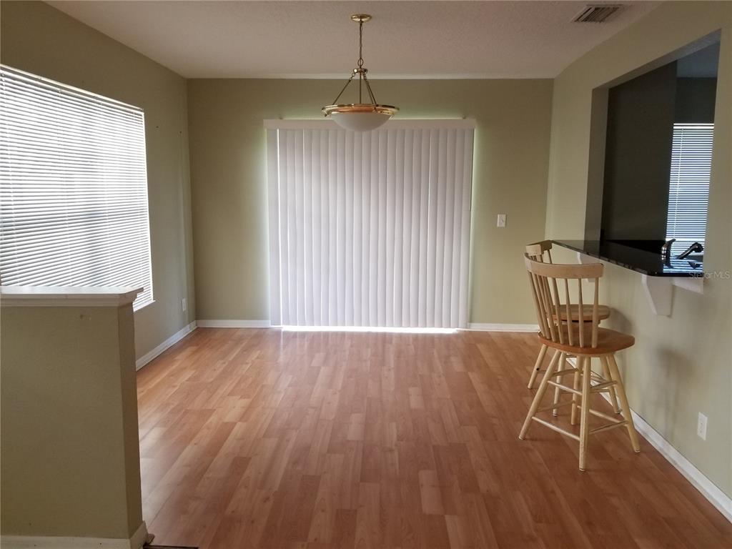219 Drawbridge Lane Valrico, FL 33594 - Photo 2 of 24 a view of a room with wooden floor windows and chairs