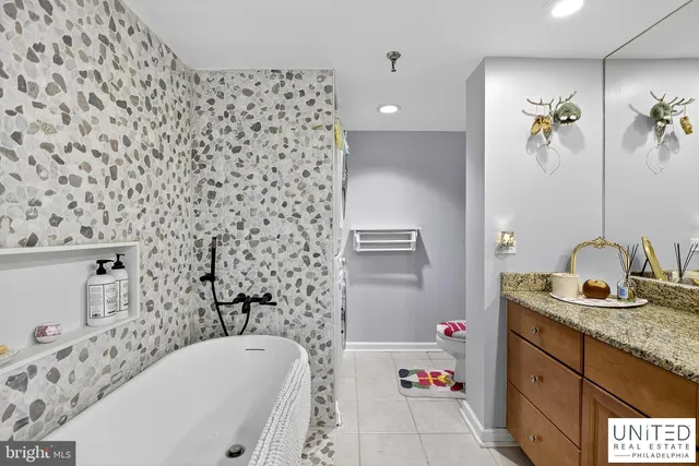 a bathroom with a bathtub sink vanity and shower