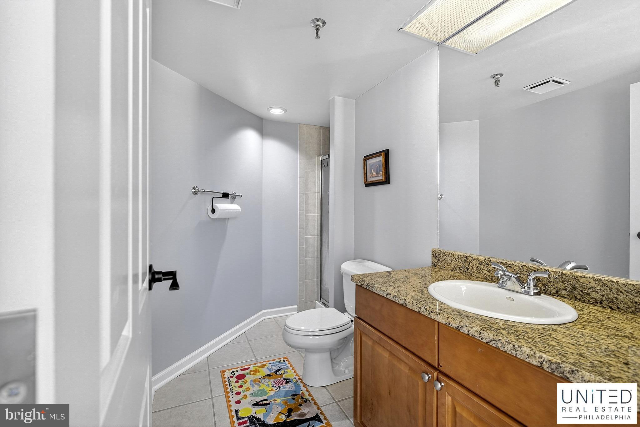 2001 Hamilton Street, Unit 2001 Philadelphia, PA 19130 - Photo 25 of 46 a bathroom with a granite countertop sink toilet and shower