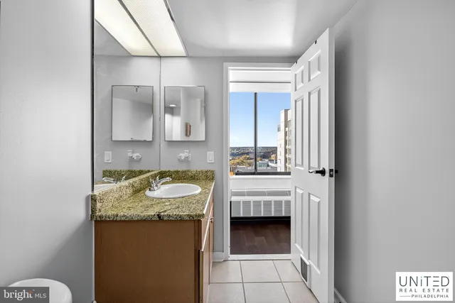 a bathroom with a granite countertop sink and a mirror