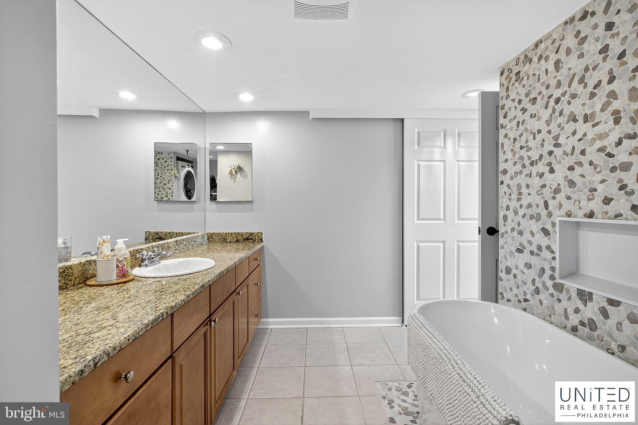 2001 Hamilton Street, Unit 2001 Philadelphia, PA 19130 - Photo 32 of 46 a bathroom with a granite countertop sink and a bathtub