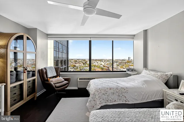 a living room with a bed furniture and a large window