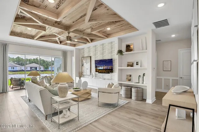 a living room with furniture a flat screen tv and a floor to ceiling window