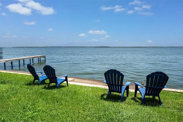 a view of a chair and table in backyard of the house