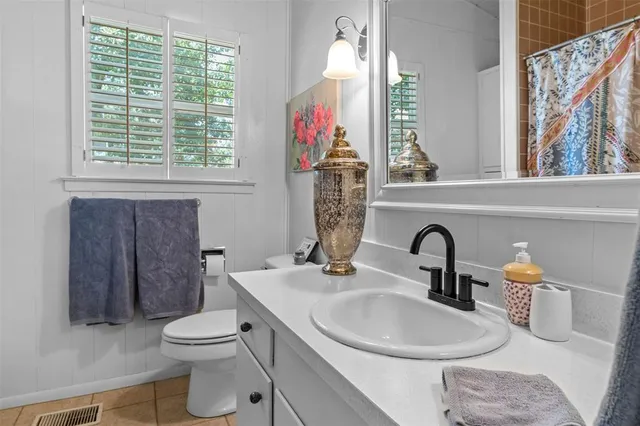 a bathroom with a toilet a sink and a window