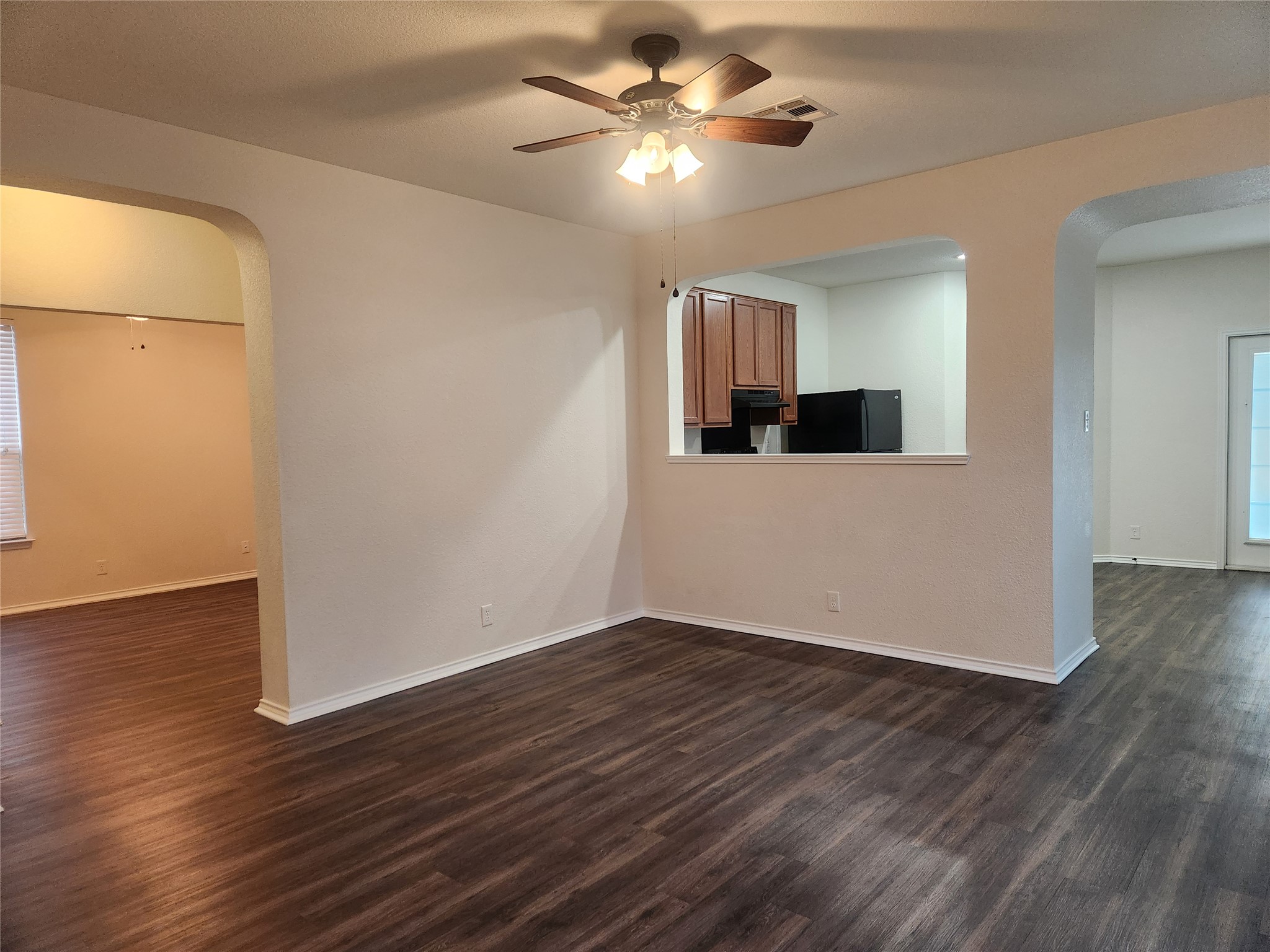 a view of a room with wooden floor and ceiling fan