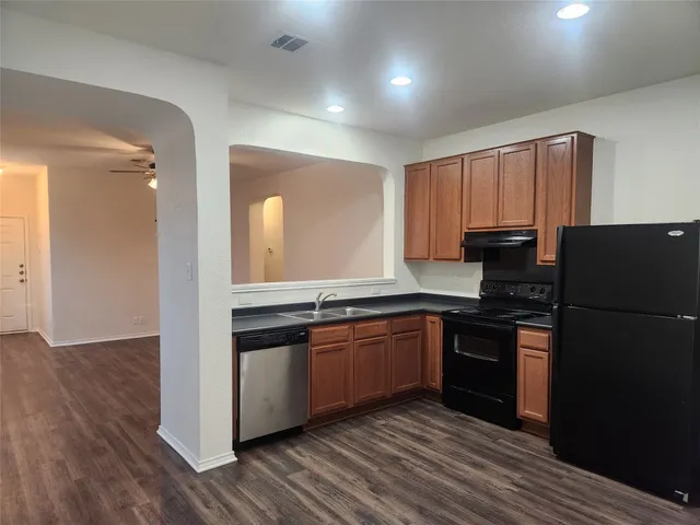 a kitchen with granite countertop stainless steel appliances and wooden cabinets