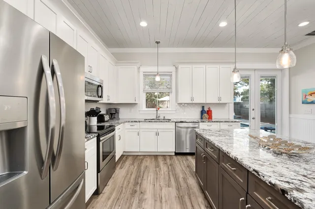 a kitchen with stainless steel appliances granite countertop a sink refrigerator and cabinets