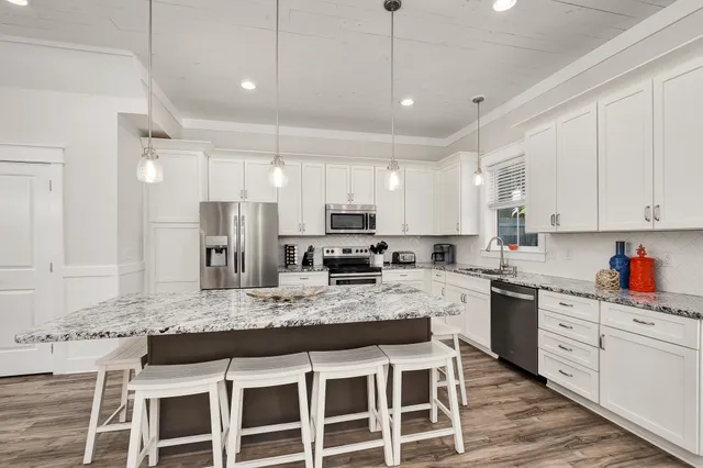 a large kitchen with kitchen island granite countertop a large counter top appliances and cabinets
