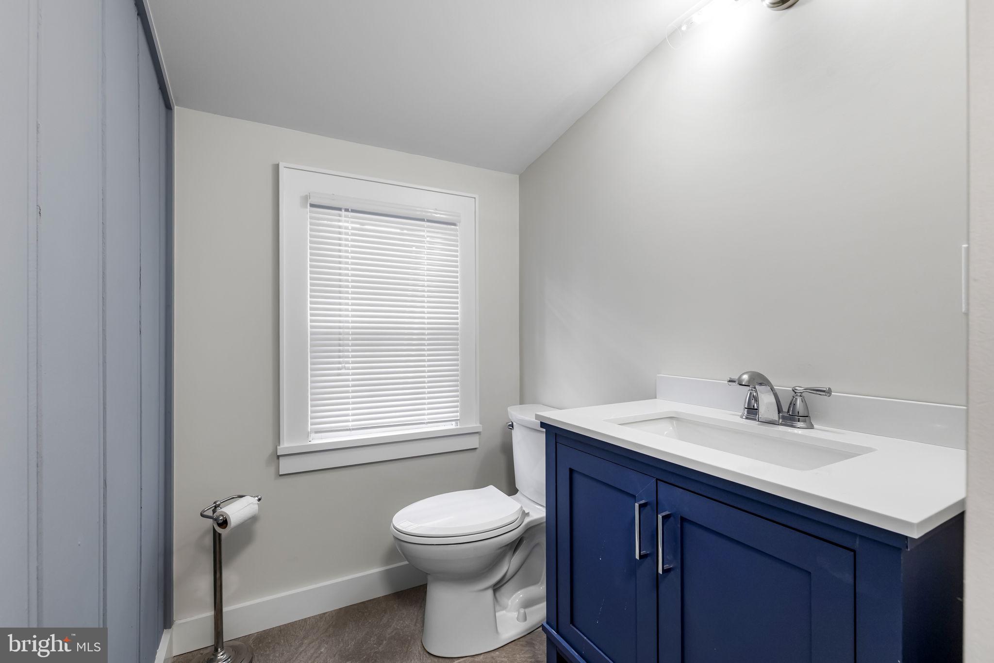 765 Dividing Road Severna Park, MD 21146 - Photo 10 of 17 a bathroom with a toilet a sink a window and mirror