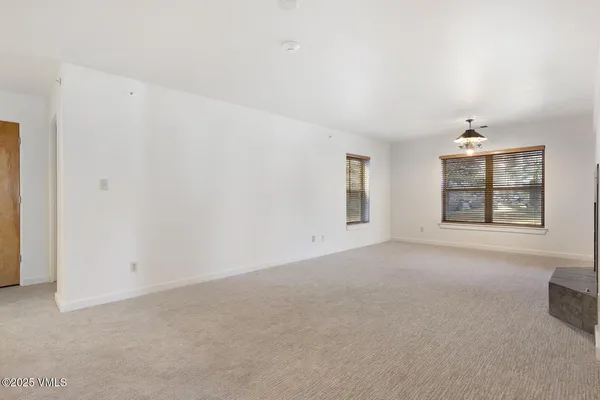 an empty room with windows and ceiling fan